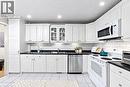 White cabinetry and dark countertops complemented by a subway tile backsplash - 1270 Gainsborough Drive Unit# 61, Oakville, ON 