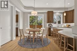 Wood-finish flooring throughout, with a recessed ceiling detail, and a sliding glass door providing access to the exterior - 