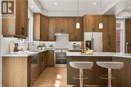 Wood-finish cabinetry, stainless steel appliances, a white countertop, and recessed lighting - 279 Hess Street S, Hamilton, ON 