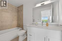 Full bathroom with bathing tub / shower combination, vanity, and light tile patterned floors - 
