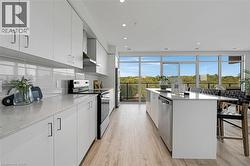 Kitchen featuring white cabinetry, stainless steel appliances, light stone countertops, and recessed lighting - 
