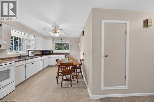Spacious kitchen featuring extensive white cabinetry, durable tile flooring, and a ceiling fan with integrated lighting - 799 Highway 6, Caledonia, ON 