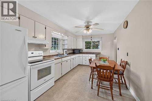 Kitchen featuring white cabinetry, a complete set of white appliances, and a ceiling fan with integrated lighting - 799 Highway 6, Caledonia, ON 