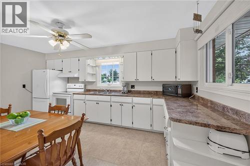 Kitchen featuring white cabinetry, a built-in range, a built-in refrigerator, a ceiling fan with integrated lighting, and a double-basin sink - 799 Highway 6, Caledonia, ON 