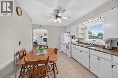 Kitchen featuring white cabinetry, a double basin sink, white appliances, and a ceiling fan - 799 Highway 6, Caledonia, ON 