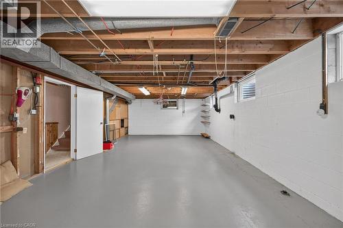 Finished concrete flooring, exposed ceiling joists, white painted block walls, and built-in shelving - 799 Highway 6, Caledonia, ON 