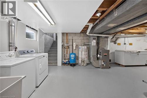 Concrete block walls with painted flooring, utility sink, and installed water heater - 799 Highway 6, Caledonia, ON 