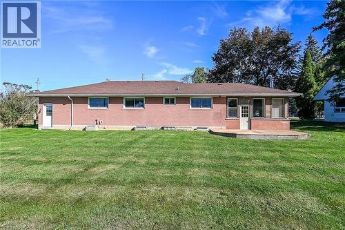 Brick exterior with multiple windows, leading to a rear deck - 799 Highway 6, Caledonia, ON 