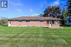 Brick exterior with multiple windows, leading to a rear deck - 