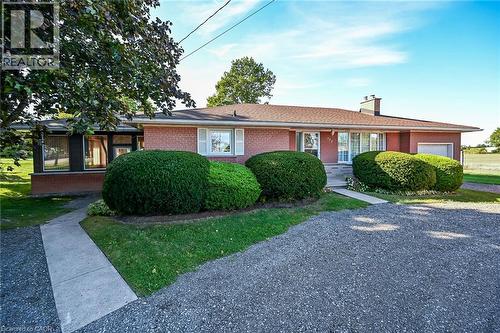 Brick exterior with white window shutters and a concrete walkway - 799 Highway 6, Caledonia, ON 