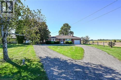 Brick exterior with white trim, attached garage, and a gabled roof - 799 Highway 6, Caledonia, ON 