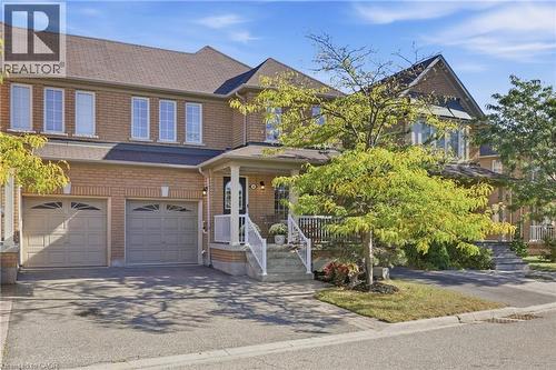 Brick exterior, multiple windows, two-car garage, covered porch with columns, paved driveway - 2409 Postmaster Drive, Oakville, ON 