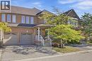 Brick exterior, multiple windows, two-car garage, covered porch with columns, paved driveway - 2409 Postmaster Drive, Oakville, ON 