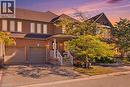 Brick exterior with two-car garage, covered porch, and paved driveway - 2409 Postmaster Drive, Oakville, ON 
