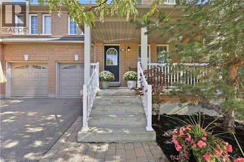 Brick facade with two garage doors and upper-level windows - 2409 Postmaster Drive, Oakville, ON 