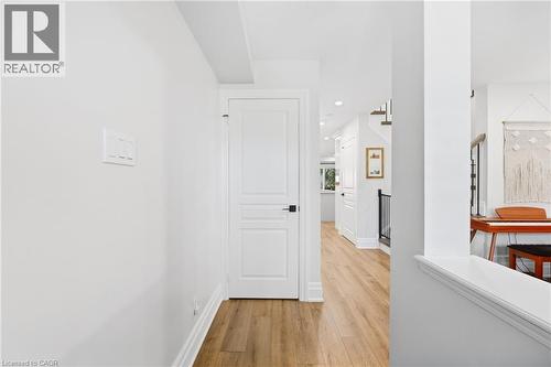 Hardwood-finish flooring, white paneled doors with black hardware, recessed lighting, and white baseboards - 2409 Postmaster Drive, Oakville, ON 