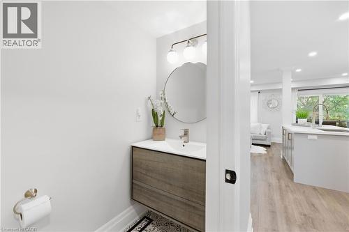 Floating vanity with wood-finish cabinetry, under-mount sink, and wall-mounted light fixture - 2409 Postmaster Drive, Oakville, ON 