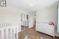 Recessed lighting, wood-finish flooring, white trim, and a frosted glass chandelier - 