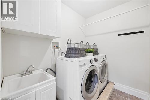 White upper cabinetry, utility sink with base cabinet, and an integrated drying rod - 2409 Postmaster Drive, Oakville, ON 