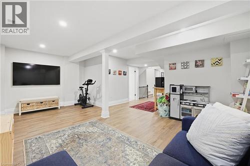 Expansive finished lower level featuring wood-finish flooring, recessed lighting, white trim, and architectural columns - 2409 Postmaster Drive, Oakville, ON 