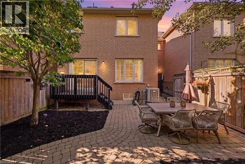Brick exterior, rear wood deck with railing, sliding glass door, and paver patio - 2409 Postmaster Drive, Oakville, ON 