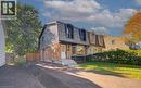 Gambrel roofline with dormer windows, brick lower facade, and mature landscaping - 210 Ferguson Avenue, Cambridge, ON 