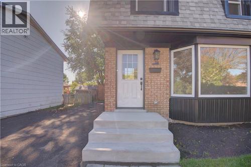 Brick exterior with a prominent bay window, asphalt driveway, concrete entry steps, and a glass-paneled entry door - 210 Ferguson Avenue, Cambridge, ON 