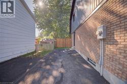 Brick exterior with a utility meter, a finished basement window, and an asphalt driveway - 