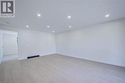 Recessed lighting, wood-finish flooring, white walls, and white trim - 