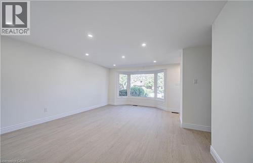 Recessed lighting, wood-finish flooring, bay window, white walls, and white trim - 210 Ferguson Avenue, Cambridge, ON 