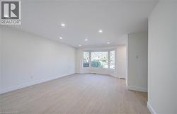 Recessed lighting, wood-finish flooring, bay window, white walls, and white trim - 