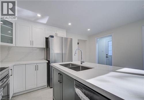 Kitchen featuring white shaker cabinetry, stainless steel appliances, quartz countertops, a dual basin sink, and recessed lighting - 210 Ferguson Avenue, Cambridge, ON 