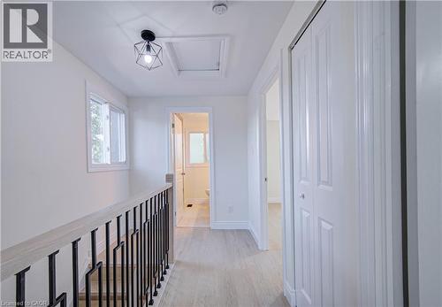 Light wood-finish flooring, white walls, and a modern geometric ceiling light fixture - 210 Ferguson Avenue, Cambridge, ON 