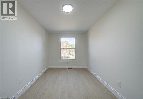 Bright room featuring light-toned wood-finish flooring, a single window, and a flush-mount ceiling light - 210 Ferguson Avenue, Cambridge, ON 