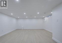 Recessed ceiling lighting, light wood-finish flooring, white wall paint, and a window - 