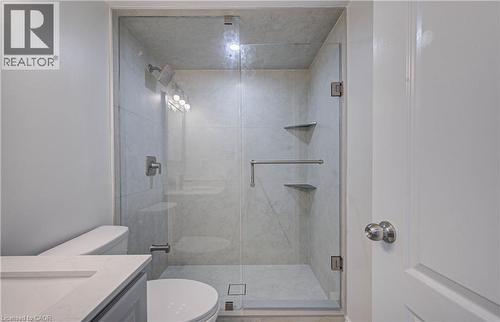 Glass-enclosed shower with tiled walls and floor, featuring a multi-function showerhead and built-in shelving - 210 Ferguson Avenue, Cambridge, ON 