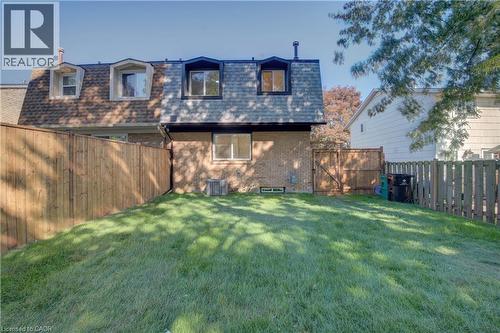 Expansive grassy yard with wood fencing, brick exterior, and dormer windows - 210 Ferguson Avenue, Cambridge, ON 