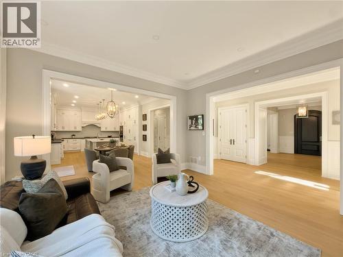 Light wood-finish flooring throughout, white trim, recessed lighting, and crown molding - 236 Poplar Drive, Burlington, ON 