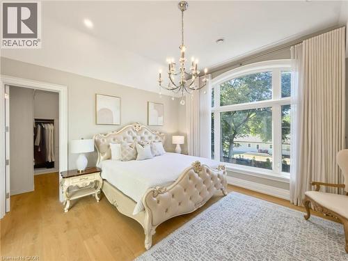 Arched picture window, wood-finish flooring, built-in closet, chandelier lighting, and a neutral color palette - 236 Poplar Drive, Burlington, ON 
