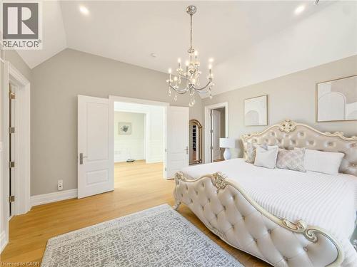 Vaulted ceiling with a crystal chandelier, wood-finish flooring, and white double doors - 236 Poplar Drive, Burlington, ON 