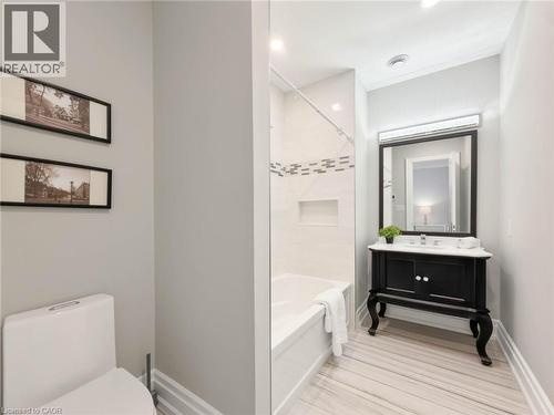 White tile flooring, a dark vanity with a white countertop, and a recessed shower niche - 236 Poplar Drive, Burlington, ON 
