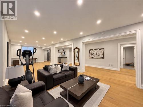 Expansive open-concept living area with wood-finish flooring, recessed lighting, a built-in wet bar, and cased openings - 236 Poplar Drive, Burlington, ON 