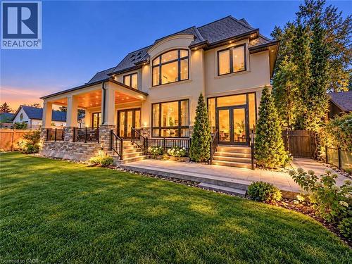 Stucco exterior with extensive window placements and a covered patio - 236 Poplar Drive, Burlington, ON 