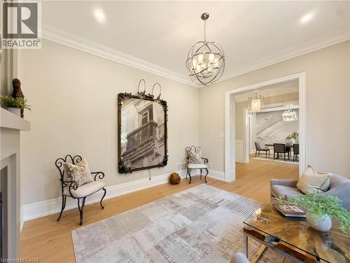 Hardwood flooring with crown molding, recessed lighting, and a contemporary spherical chandelier - 236 Poplar Drive, Burlington, ON 