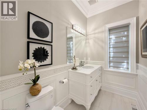 White vanity with a single basin, paneling, and a decorative tile accent - 236 Poplar Drive, Burlington, ON 