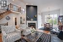 Two-story living area with hardwood flooring, a fireplace, and a built-in staircase with iron balusters - 4285 Couples Crescent, Burlington, ON 