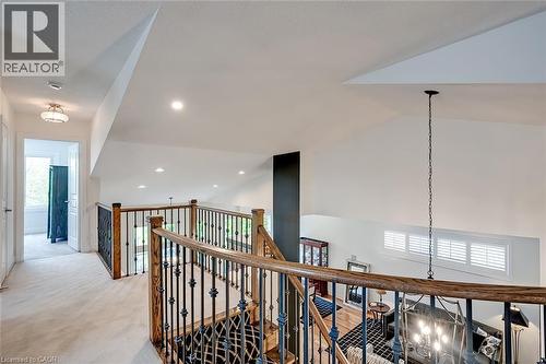Spacious landing featuring a wood and wrought iron staircase, recessed lighting, and a vaulted ceiling - 4285 Couples Crescent, Burlington, ON 