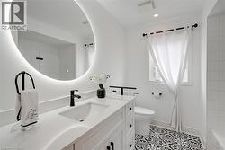 White vanity with a rectangular undermount sink, matte black faucet, and white countertop - 