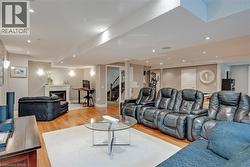 Recessed lighting, wood-finish flooring, white fireplace, built-in staircase, and wall sconces - 
