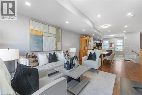 Open-concept living space featuring recessed lighting, wood-finish flooring, and light gray wall paint - 1380 Costigan Road Unit# 13, Milton, ON 